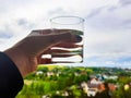 a glass of water in your hand against the sky Royalty Free Stock Photo