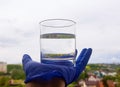 a glass of water in your hand against the sky Royalty Free Stock Photo