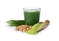 Glass of wheat grass juice, seeds, sprouts and scoop with powder