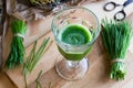 A glass of wheatgrass juice with fresh wheatgrass