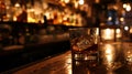 a glass of whiskey on a bar top with bottles in the background