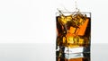 Glass of Whiskey or Brandy. Splash in a Glass on white background. Alcohol Drink. Clear ice in cube shape.