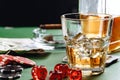 Glass of whiskey, cigar, playing cards and chips on green background Royalty Free Stock Photo