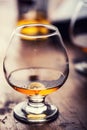 Glass whiskey cognac brandy or rum.One half full glasses of cognac on a wooden surface Royalty Free Stock Photo