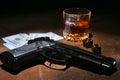 Glass of whiskey or cognac, gun, playing cards with money on the black mirror table. The concept of criminal. Royalty Free Stock Photo