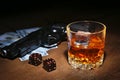 Glass of whiskey or cognac, gun, playing cards with money on the black mirror table. The concept of criminal. Royalty Free Stock Photo