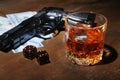 Glass of whiskey or cognac, gun, playing cards with money on the black mirror table. The concept of criminal. Royalty Free Stock Photo