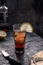 A glass of whiskey with cola full of ice with a slice of lemon on a dark background and copy space. Alcoholic cocktail Royalty Free Stock Photo