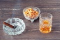 Glass of whiskey, a cuban cigar and nuts on a grey wooden table. Close-up view. Royalty Free Stock Photo