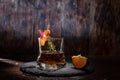 Glass of whiskey garnished with spices and orange. A glass of alcohol on the table. Composition with a glass. Royalty Free Stock Photo