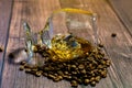 A glass of whiskey with ice and coffee beans on a wooden table. Strong alcohol with ice. Vintage close-up of golden cognac.