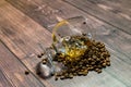 A glass of whiskey with ice and coffee beans on a wooden table. Strong alcohol with ice. Vintage close-up of golden cognac.