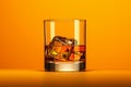 Glass of whiskey with ice cubes on orange background, panoramic shot