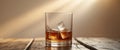 Glass of Whiskey with Ice Cubes on Table in Warm Natural Light with Soft Background. Royalty Free Stock Photo