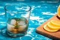 A glass of whiskey with ice and lemon on a vintage table