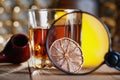 Glass of whiskey, magnifying glass, lemon and smooking pipe Royalty Free Stock Photo