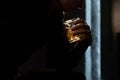 Glass with whiskey  in a man`s hand on a black background Royalty Free Stock Photo