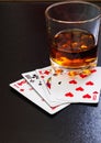 Glass of whiskey and playing cards on a black desk on the wooden table. Angle view, identification cards Royalty Free Stock Photo