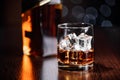 A glass of whiskey on the rocks and a bottle on the table. Royalty Free Stock Photo