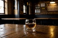 glass of whiskey or rum on old wooden table in empty pub interior Royalty Free Stock Photo