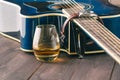 Glass of whiskey on the table and guitar Royalty Free Stock Photo