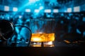 Glass with whisky with ice cube inside on dj controller at nightclub. Dj Console with club drink at music party in nightclub with Royalty Free Stock Photo