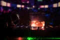 Glass with whisky with ice cube inside on dj controller at nightclub. Dj Console with club drink at music party in nightclub with