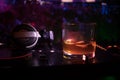 Glass with whisky with ice cube inside on dj controller at nightclub. Dj Console with club drink at music party in nightclub with Royalty Free Stock Photo