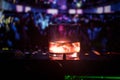 Glass with whisky with ice cube inside on dj controller at nightclub. Dj Console with club drink at music party in nightclub with