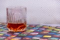 A GLASS OF WHISKY SITTING COLORFUL TABLE Royalty Free Stock Photo