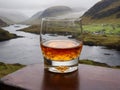 A Glass Of Whisky On A Table With A View Of A Lake. Generative AI