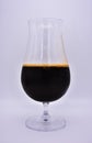 Glass on white background, glass with dark beer, glass with dark liquid, filled glass goblet on leg Royalty Free Stock Photo