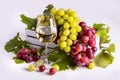 Glass with white sparkling wine, green and pink grapes with leaves in a white box