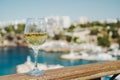 Glass of white wine against the backdrop of the Mediterranean sea and the port with yachts in a tourist town in the Royalty Free Stock Photo