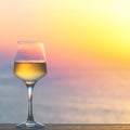 Glass of white wine against sunset. Royalty Free Stock Photo