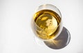 glass of white wine on white background with sparkling shadows. Free copy space. Concept of luxury drinks. Top view