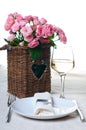 Glass of white wine and a basket of roses