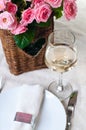 Glass of white wine and a basket of roses