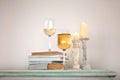 Glass of white wine, a book and two candles on the dresser Royalty Free Stock Photo