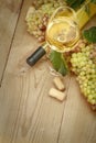 Glass of white wine bottle and grapes on a wooden table Royalty Free Stock Photo