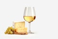 Glass of white wine, bunch of grapes and cheese on plain background with copy space Royalty Free Stock Photo