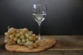 Glass of white wine and bunch of grapes on a wooden table. With copy space for text. Royalty Free Stock Photo