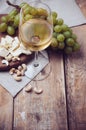 Glass of white wine, grapes, cashew nuts and soft cheese Royalty Free Stock Photo