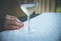 Drinking problem: Glass of white wine, hand of a woman with red nail polish Royalty Free Stock Photo