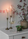 A glass of white wine, nuts, lighted candles - a cozy home evening aperitif Royalty Free Stock Photo