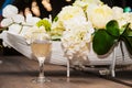 Glass of white wine over a bouquet of artificial flowers Royalty Free Stock Photo