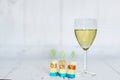 Glass of white wine, polenta with cherry tomato and chese canapes on a wooden background Royalty Free Stock Photo