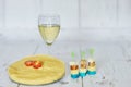 Glass of white wine, polenta with cherry tomato and chese canapes on a wooden background Royalty Free Stock Photo