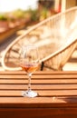 Glass of white wine on rustic wooden table and flower pots on terrace outside Royalty Free Stock Photo