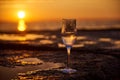 Glass of white wine and with sea and beautiful sunset at background, close-up. Summer evening relaxed mood concept Royalty Free Stock Photo